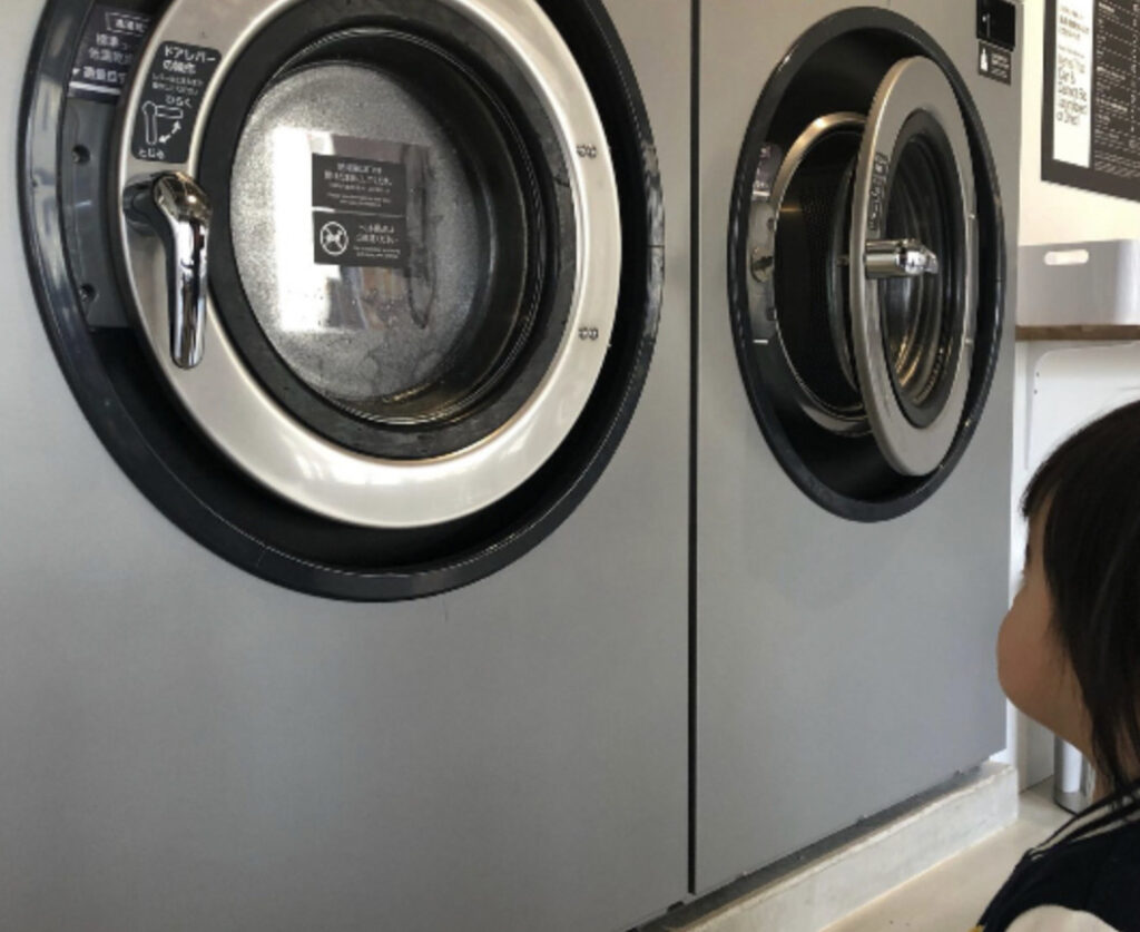 洗濯機を眺めている１歳の時の写真